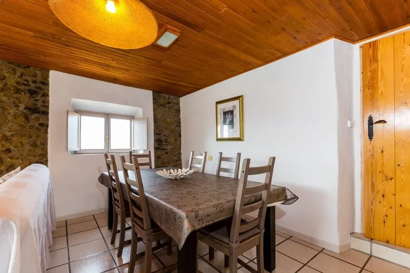 The dining table under the wooden ceiling, laid for the group.